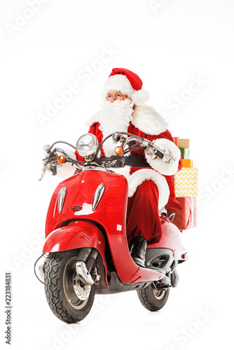 santa claus riding vintage red scooter with gift boxes isolated on white