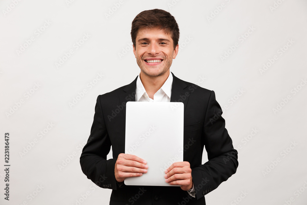 Happy cheerful businessman standing isolated holding laptop computer. Happy cheerful businessman standing isolated holding laptop computer.