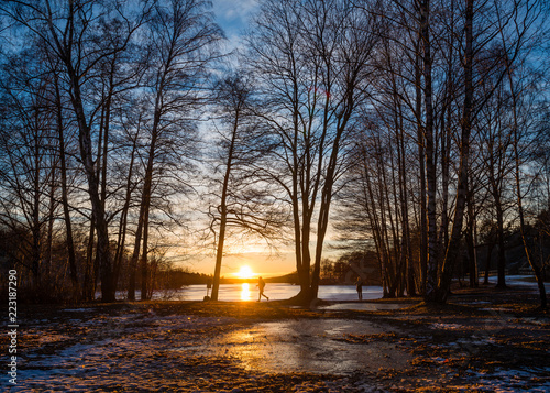 Man running and woman taking a photo of sunset