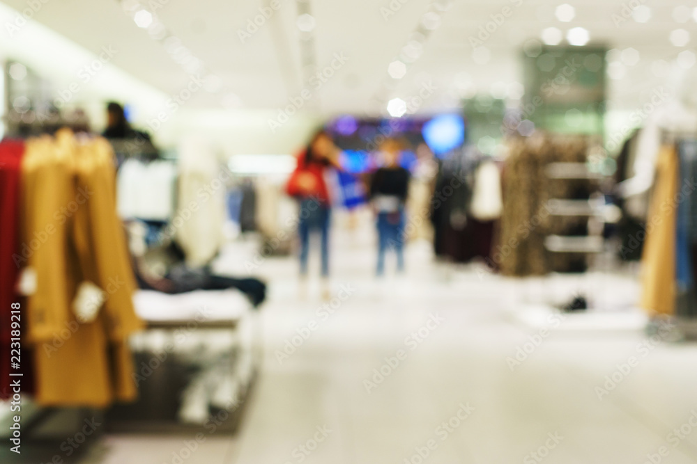 Obraz premium Blurred modern fashion store. Buyers choose the clothes.