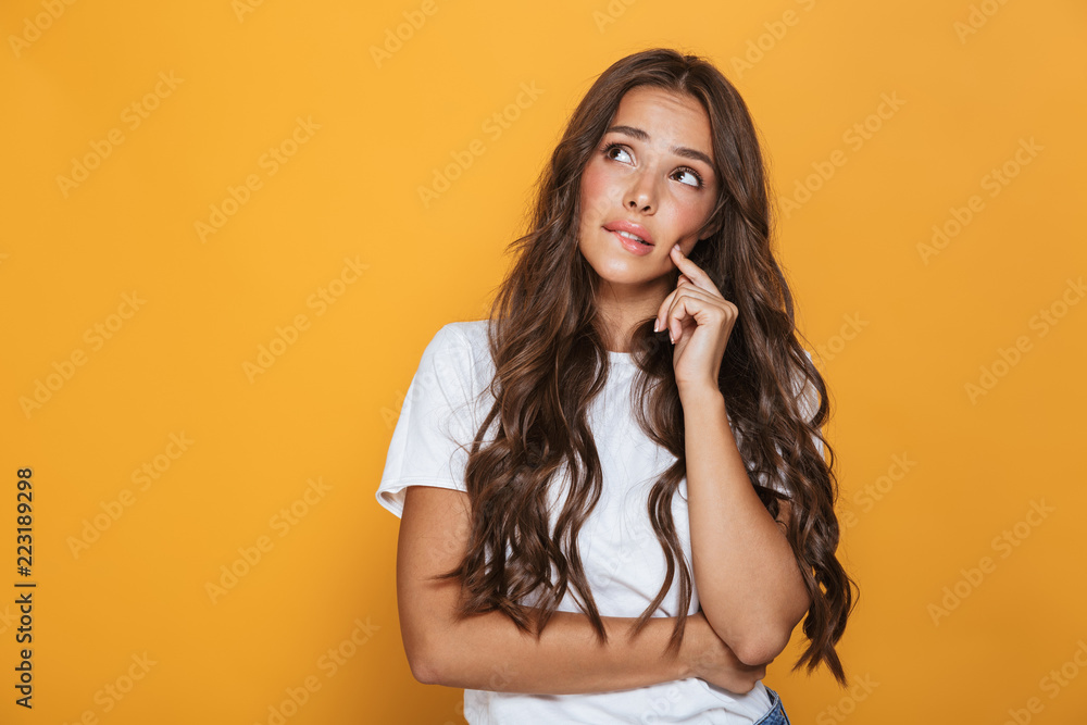 Obraz premium Obraz 20s pięknej kobiety z długimi włosami, patrząc na bok na copyspace, odizolowane na żółtym tle