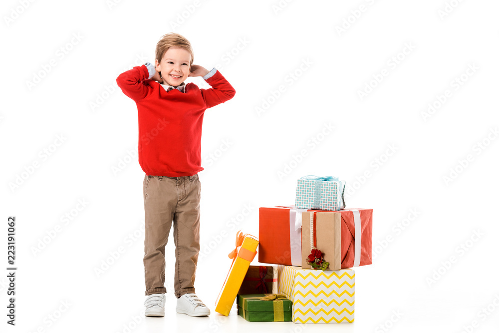 smiling little kid with pile of christmas gifts isolated on white smiling little kid with pile of christmas gifts isolated on white