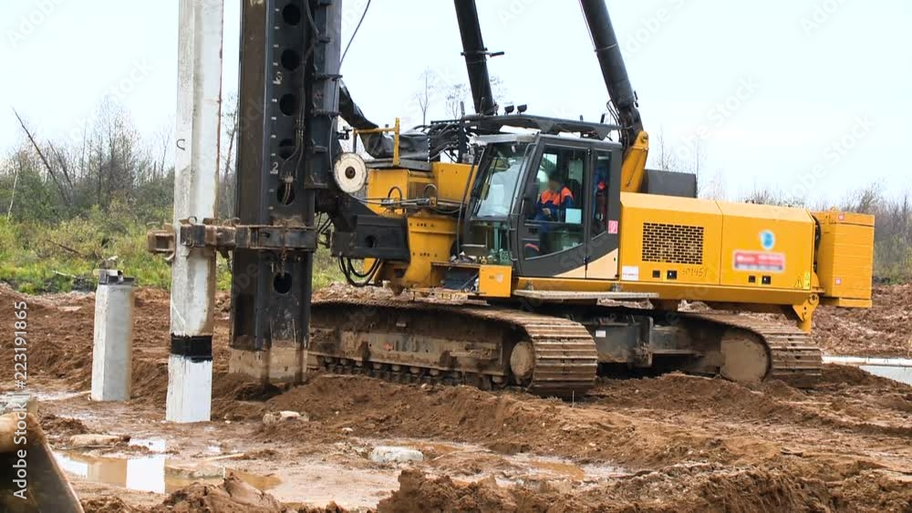 Construction of the road on the bridge. Worker on a machine with a hammer at a construction site Construction of the road on the bridge. Worker on a machine with a hammer at a construction site
