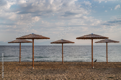 Empty beach early in the morning, parasols. Season is over. Travel Europe, Greece.