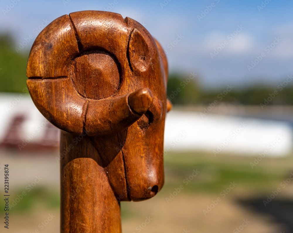 Carved head of a ram (Ovis gmelini), a sign of the devil and evil, cropped  against a deliberately blurred background. Stock Photo | Adobe Stock