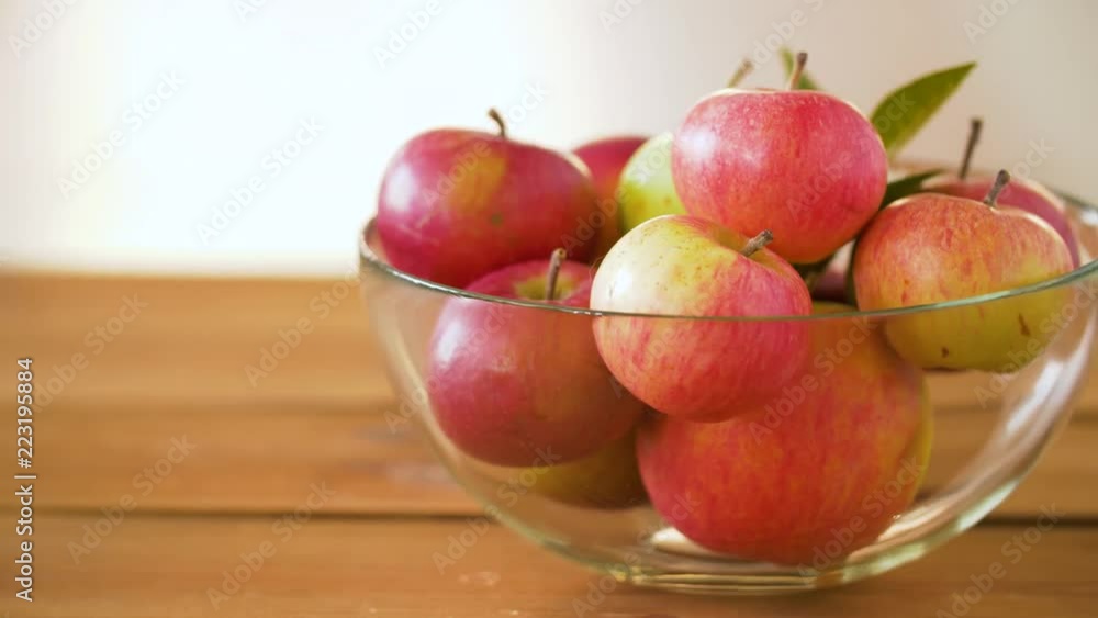 fruits, food and harvest concept - ripe apples glass bowl on wooden table fruits, food and harvest concept - ripe apples glass bowl on wooden table