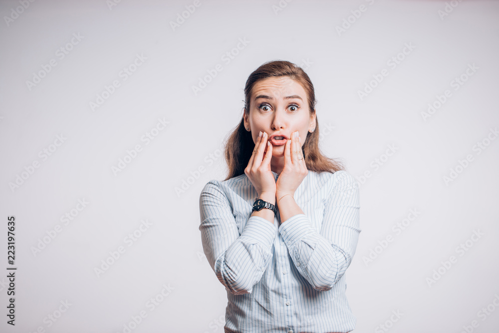 Toothache problems. Young brunette woman with two hands holding her cheeks and looking at the camera Toothache problems. Young brunette woman with two hands holding her cheeks and looking at the camera