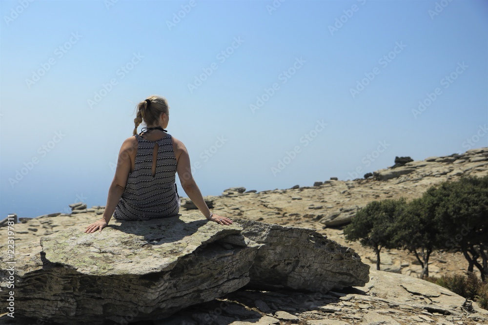 lonesome woman sitting on a rock overseeing a beautiful luna landsacepe