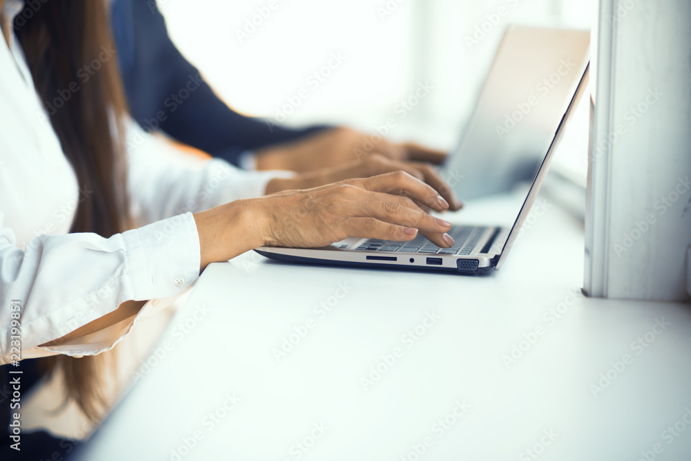 Group of business people working in the office. Man and woman typing message on laptop.