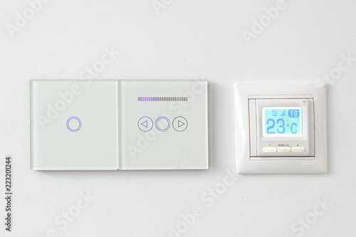 smart home system, switches and floor heating on white wall. Digital thermostat temperature controller