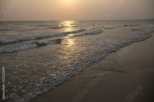 Orange sunset landscape with sea and beach sand. Sun reflection in rippled sea. Romantic evening seascape with sunset.