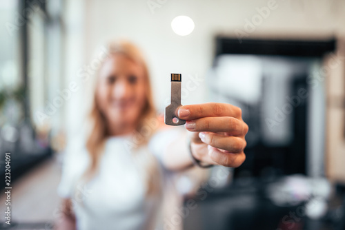 Woman holding a usb key. Focus on a foreground, on the usb. photo