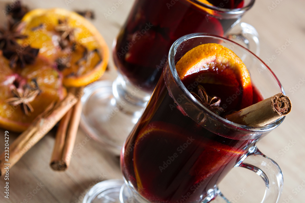 Mulled wine in glass with spice and fruit on wooden table. Mulled wine in glass with spice and fruit on wooden table.