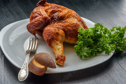 fried chicken on a white plate on a dark wooden background