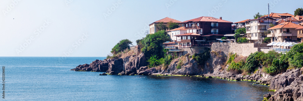 Panoramic photo of the cliff with houses and restaurants by the sea