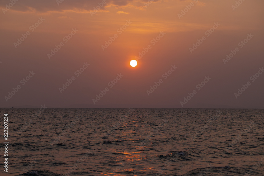 Orange sunset landscape with sea and red sun. Red orange sunset sky. Romantic evening seascape with sunset.
