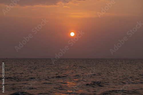Orange sunset landscape with sea and red sun. Red orange sunset sky. Romantic evening seascape with sunset.