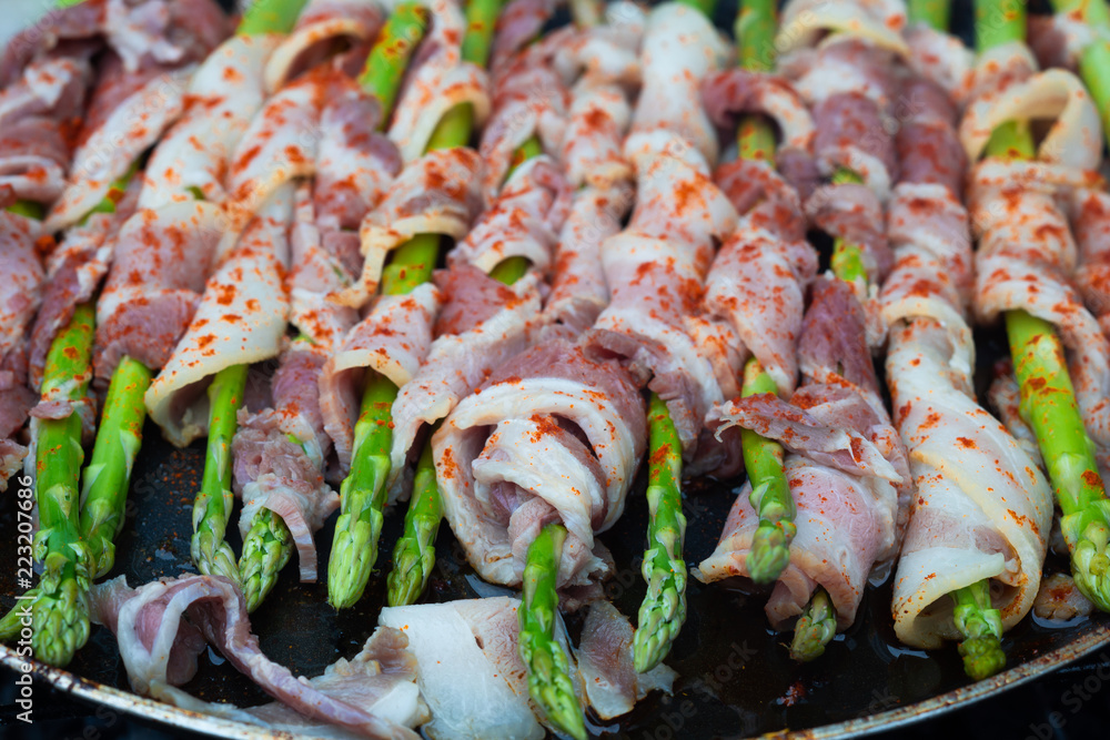 Bacon wrapped asparagus in frying pan.