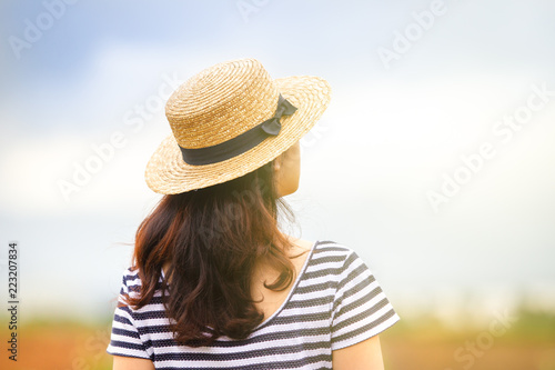 Asian women who wearing a hat looking up to the sky on natural blurred background close up.  Concept of freedom life and vision in life.