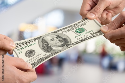 Hands holding one hundred dollars banknote