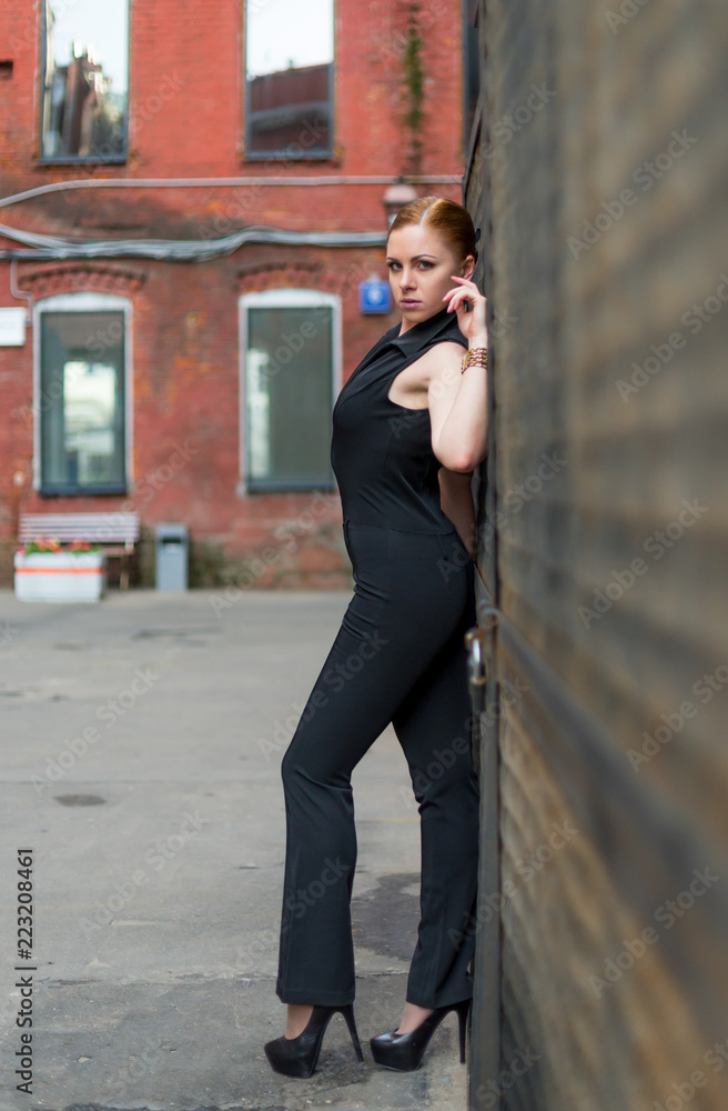 Fototapeta premium Beautiful young girl in black walks around the spring city