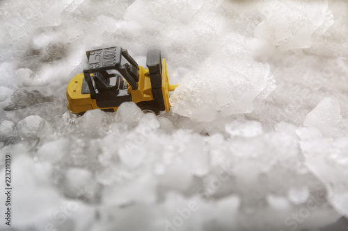 yellow digger toy on the snow