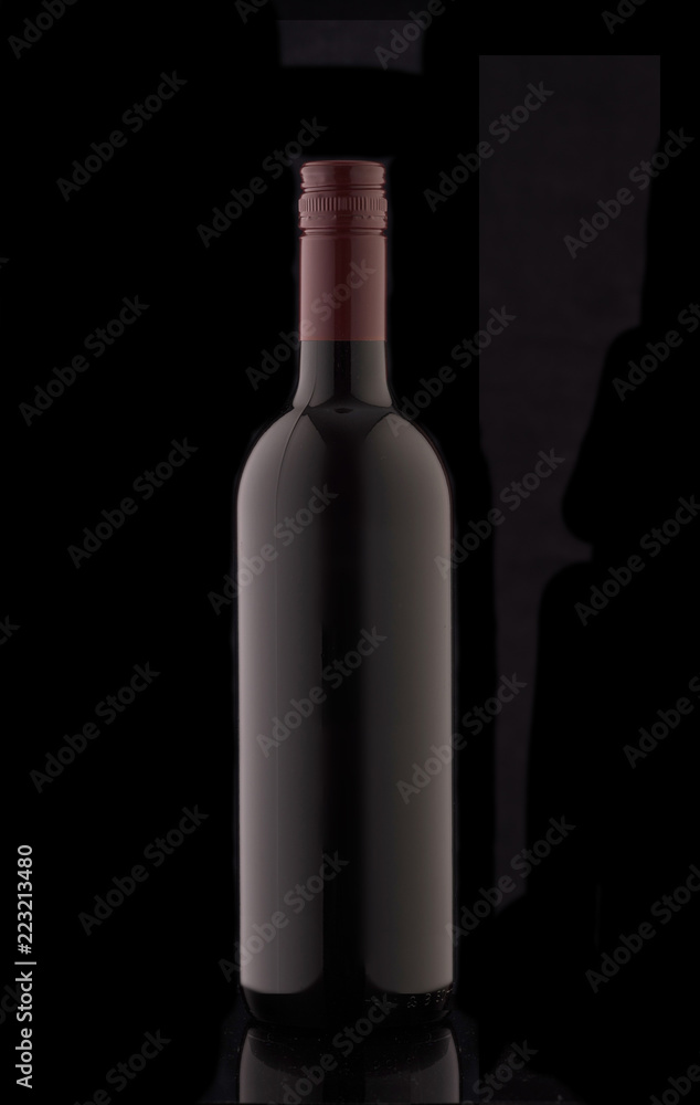 A bottle of red elite wine on a black background. Silhouette of a bottle of wine with a red stopper. A bottle of red elite wine on a black background. Silhouette of a bottle of wine with a red stopper.