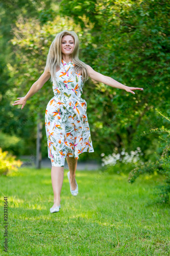 Beautiful young girl in a dress walking in the summer Park Beautiful young girl in a dress walking in the summer Park