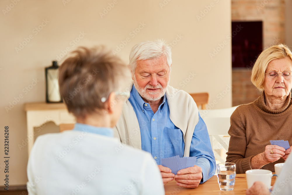 Drei Senioren spielen zusammen Karten Drei Senioren spielen zusammen Karten