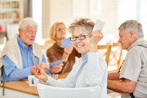 Ehrgeizige Senior Frau beim Karten spielen
