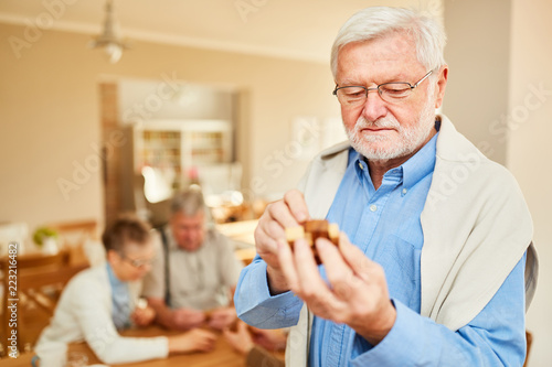 Senior Rentner Mann spielt mit einem Holzpuzzle