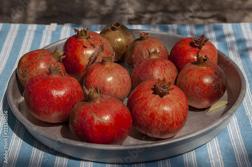 Red pommegranades in metal tray on blue and white stiped cotton table cloth at Tenedos (Bozcaada) Island by Aegean Sea