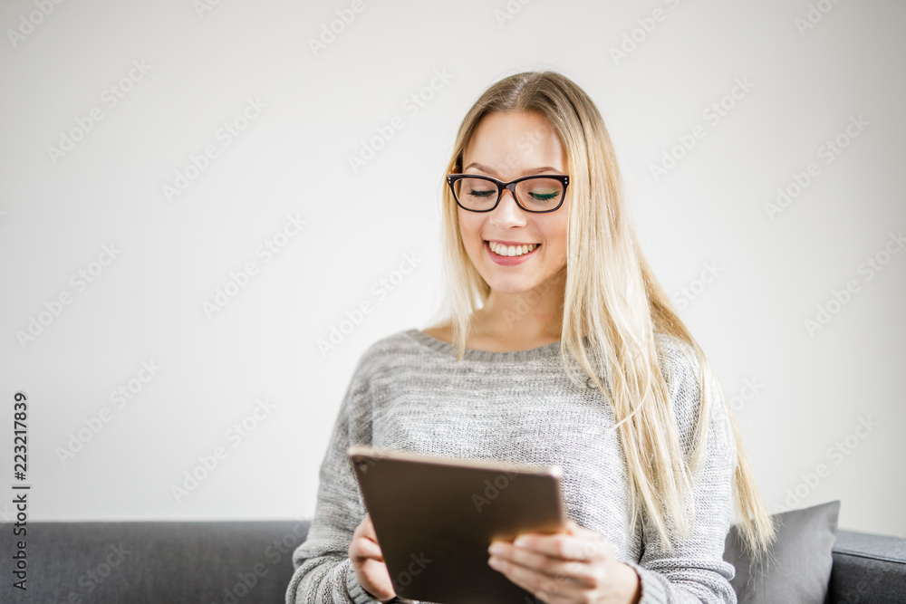 Eine junge Frau freut sich über eine Nachricht auf ihrem Tablet Eine junge Frau freut sich über eine Nachricht auf ihrem Tablet