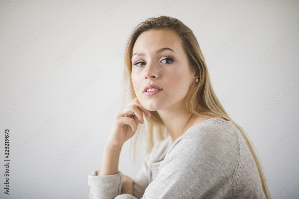 Frau sitzt vor einer weißen Wand Frau sitzt vor einer weißen Wand