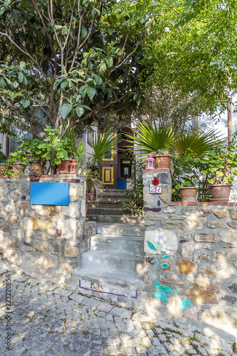 Elevated house entrance with stone steps and flowers on sides at Tenedos (Bozcaada) Island by the Aegean Sea