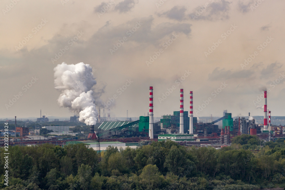 Coal processing plant operates on the river bank. Smoke from the pipes pollutes the atmosphere of the city. Concept of pollution of the environment, emissions into water resources. Industrial landscap