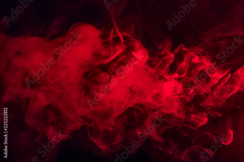 Colorful smoke on a black background of red and white colors. The concept of smoking. Beautiful textural background