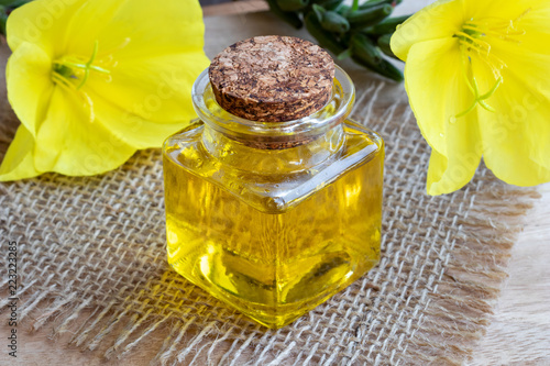 A bottle of evening primrose oil with fresh blooming evening primrose