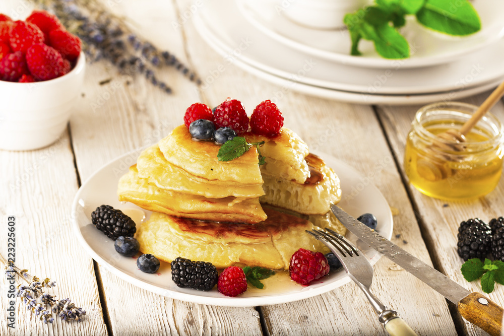 Pancakes with forest fruits berries on white table. Pancakes with forest fruits berries on white table.
