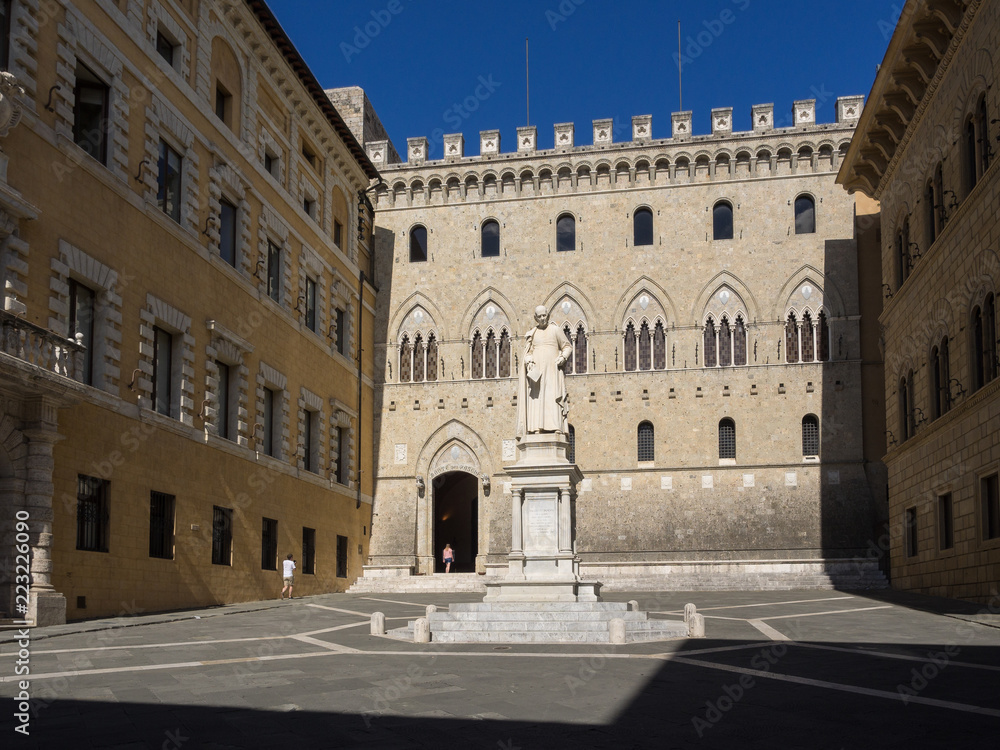 Historischer Palazzo in Siena mit Denkmal im Sonnenschein, Siena, Toskana, Italien