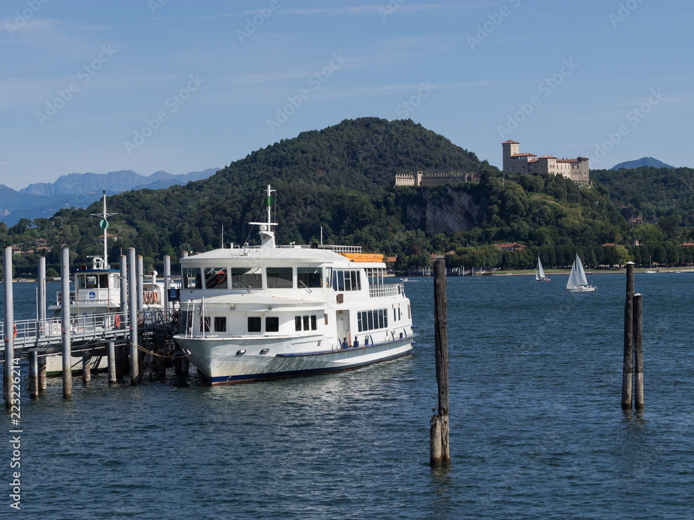 Schiffsanleger mit weißem Dampfer und Burg im Hintergrund, Arona, Lago Maggiore, Italien Schiffsanleger mit weißem Dampfer und Burg im Hintergrund, Arona, Lago Maggiore, Italien