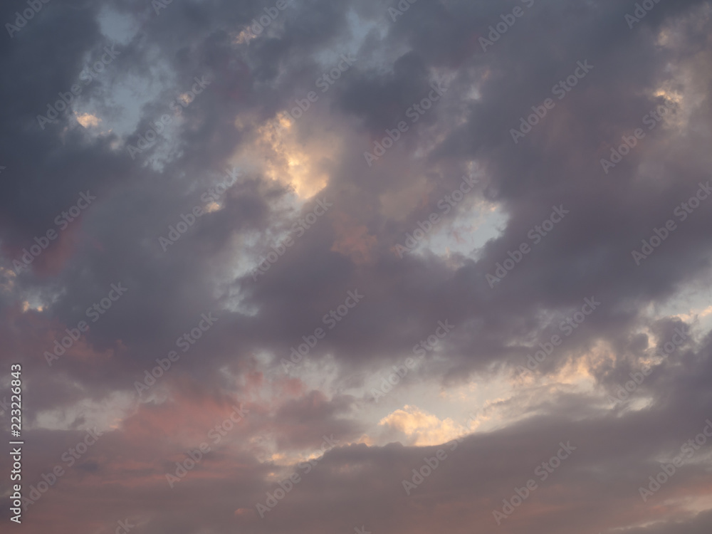 Texture, background, pattern. Sunset or dawn colored clouds, pink, dark blue, orange, pastel colors. Romantic sky at dusk with dynamic dramatic expressive clouds