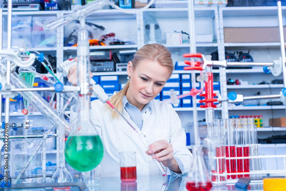 Female laboratory assistant with chemical experiment in scientific laboratory. Female medical or scientific researcher using test tube on laboratory. Female laboratory assistant with chemical experiment in scientific laboratory. Female medical or scientific researcher using test tube on laboratory.