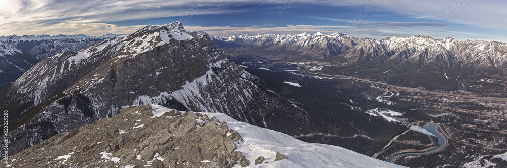Scenic Wide Panoramic Landscape View of Bow Valley, City of Canmore and Distant Snowy Rocky Mountain Tops in Banff National Park from summit of Ha Ling Peak in Alberta Canada
