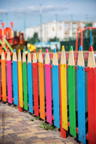 decorative fence in the form of pencils against the blue sky