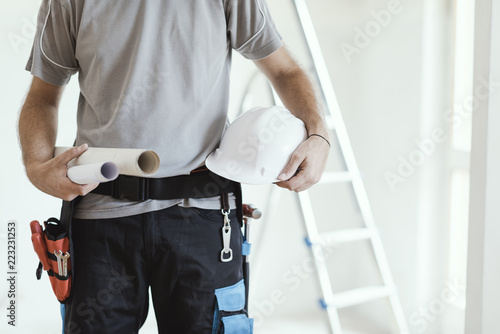 Construction engineer holding safety helmet and projects