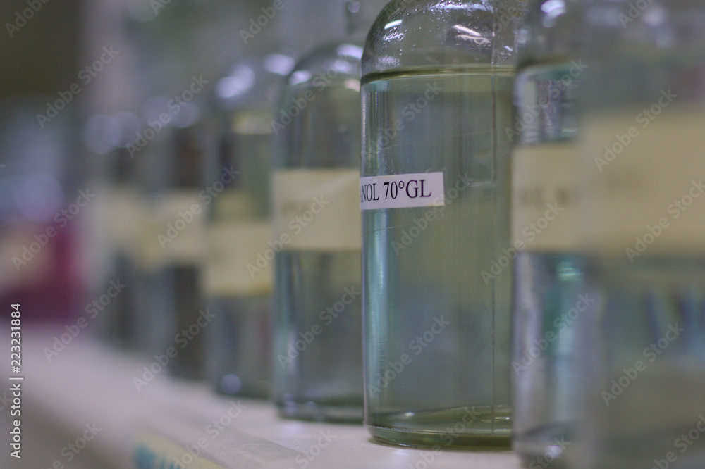 Glass bottles aligned with colorless liquid inside Glass bottles aligned with colorless liquid inside