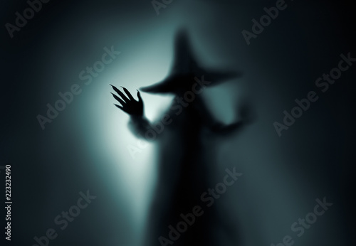 Cuadro en lienzo Creepy witch silhouette behind a frozen glass and in the mist with backlit