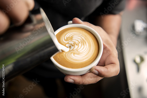 Barista making coffee latte art or Cappuccino in coffee shop.