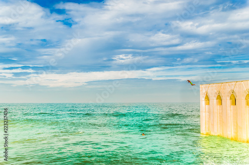 People jumping in Mediterranean sea next to Hassan II Mosque